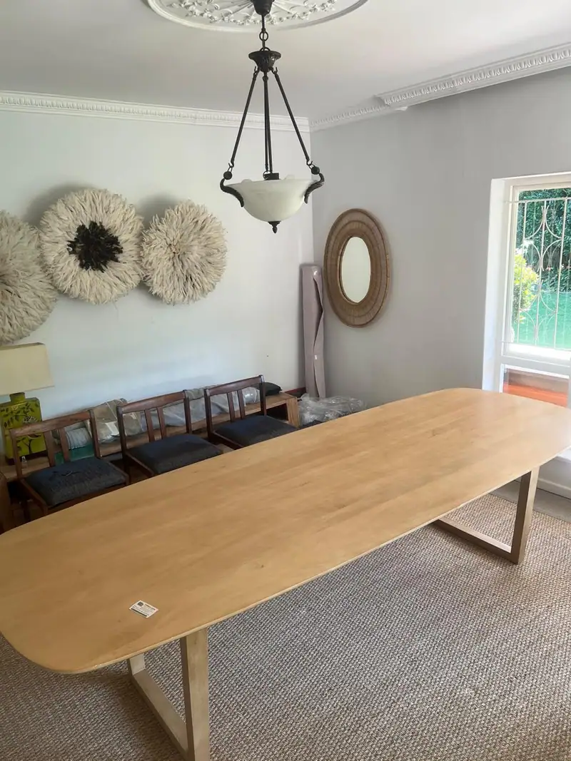 Oval dining table set up in a customer's dining room after delivery