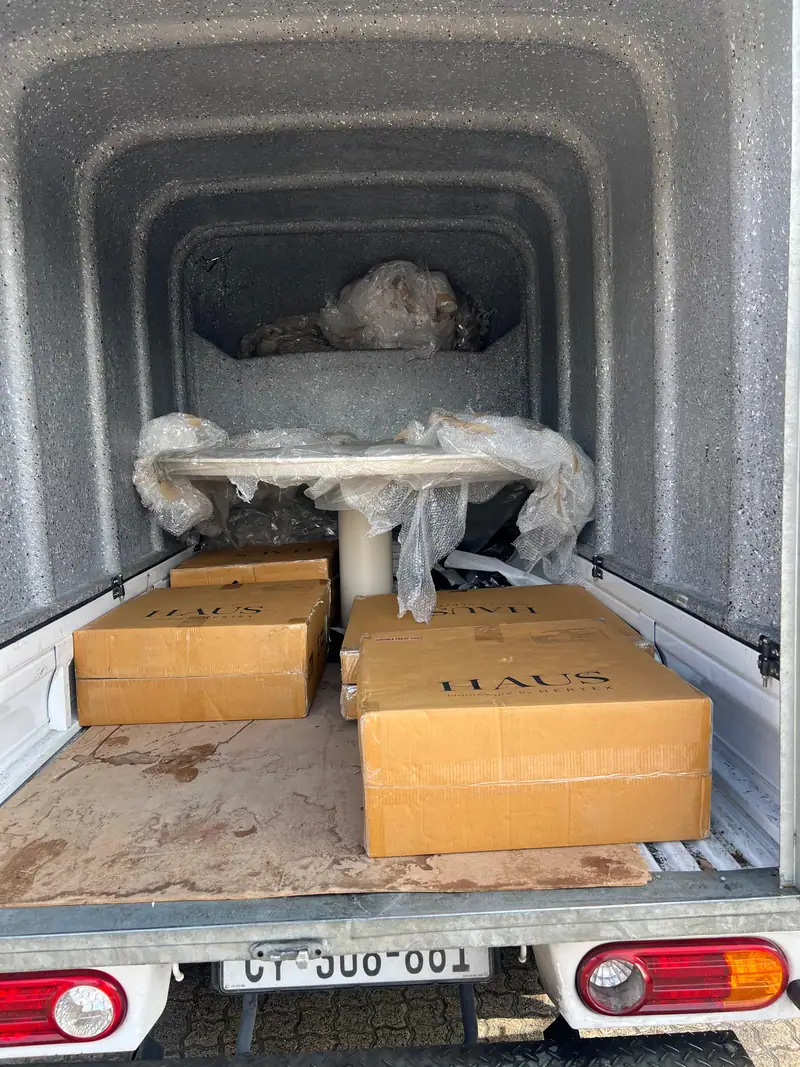 Table and boxed furniture secured inside a delivery truck