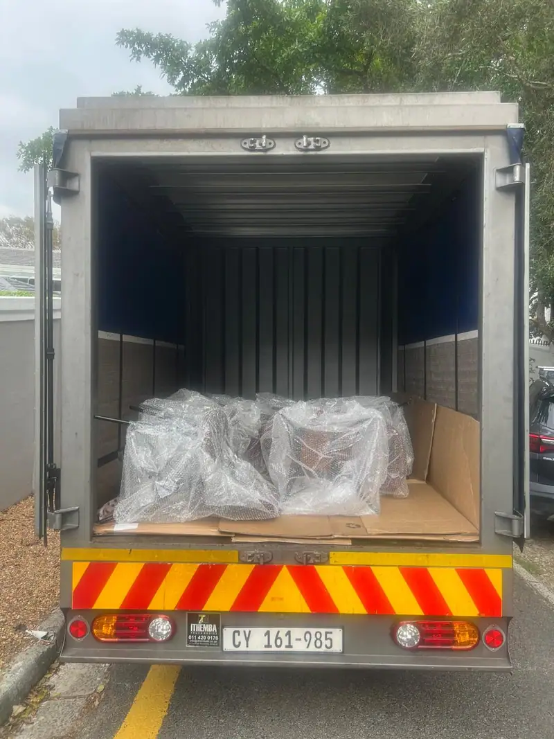 Delivery truck loaded with bubble-wrapped chairs
